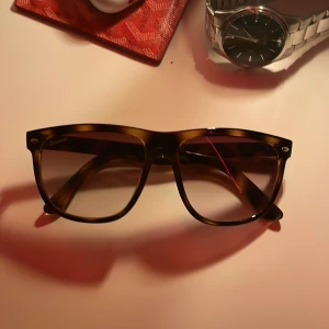 Solglasögon från OneWear - Snygga solglasögon från OneWear med en trendig brun båge och tonade linser. Perfekta för att ge din stil en extra touch. Kommer med ett stilrent fodral för säker förvaring.