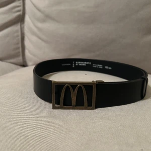 Svart bälte med McDonald's-spänne - Snyggt svart bälte med ett unikt McDonald's-spänne i metall. Har aldrig anbänts