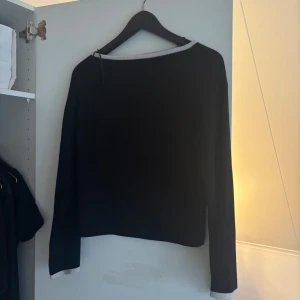 Svart långärmad tröja från Gina Tricot - Säljer en stilren svart långärmad tröja från Gina Tricot. Tröjan har en kontrasterande vit kant vid halsringningen som ger en snygg detalj. Perfekt för en enkel och elegant look. Storlek L men skulle säga att det är en M, inköpspris 400🥰