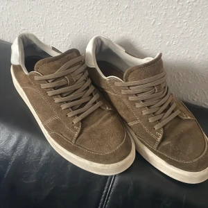 Olivgröna sneakers från Vagabond - Snygga olivgröna sneakers från Vagabond i skinn med snörning. De har en vit sula och vita detaljer vid hälen. Perfekta för en avslappnad stil.