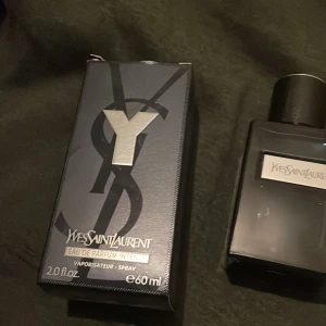 Yves Saint Laurent Y Eau de Parfum Intense - Säljer en elegant och intensiv parfym från Yves Saint Laurent. Flaskan är stilrent designad i mörkblått glas med en svart kork och en silverfärgad etikett. Perfekt för den som söker en sofistikerad doftupplevelse. Ca 59  ml som du ser på bilden köpt på kicks.
