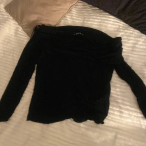 Svart offshoulder topp från Gina Tricot - Snygg svart offshoulder topp från Gina Tricot i storlek XL, Perfekt för en stilren look med långa ärmar och mjukt material. Passar utmärkt till både jeans och kjol. 