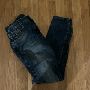 Blå Anbass Replay jeans med slitningar - Blåa Replay jeans med några hål men inget som märks jätte mycket, har använt dom rätt mycket och därför är priset så lågt 