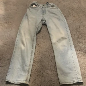 Ljusblåa jeans - Säljer ett par ljusblå jeansbyxor från Lindex. Byxorna har en klassisk design med normal passform och är tillverkade i denim. Perfekta för en avslappnad stil.
