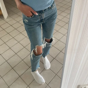 Blå jeans med slitningar - Snygga blå jeans med slitningar på knäna. De har en klassisk  rak passform. Aldrig använda köpt från pull and bear