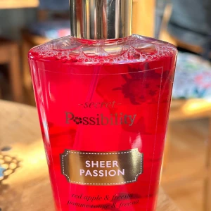 Secret Possibility Body Mist! - Secret Possibility Body Mist "Sheer Passion". 250 ml. Oanvänd.    Possibility Sheer Passion Body Mist har en söt, fruktig och blommig blandning av röda bär, äpple, melon, ananas, lilja och fresia som ger en härligt frisk och levande doftupplevelse. Perfekt för den som söker en uppfriskande och livlig doft med en touch av elegans, idealisk för både vardag och speciella tillfällen.  
