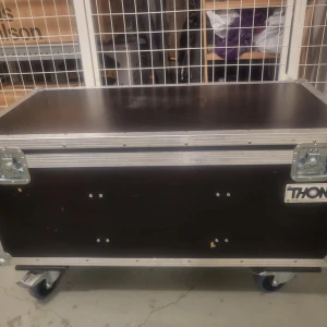 Svart resväska från Thon - Säljer en robust svart resväska från Thon med metallhörn och hjul för enkel transport. Väskan har ett slitstarkt yttre och är perfekt för att skydda utrustning under resor. Den har även handtag för smidig hantering.