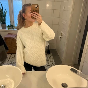 Vit stickad tröja - Säljer en mysig vit stickad tröja med ett klassiskt flätmönster, tjockt material så den är väldigt varm. Storleken är xs men det är en oversized modell, skriv för fler bilder eller frågor💕