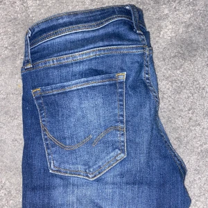 Jack & Jones slim Glenn  - Säljer ett par snygga blå jack&jones slim glenn jeans i bra skick. De har en klassisk femficksdesign och är perfekta för vardagsbruk. Jeansen har en slim passform och är tillverkade i slitstarkt denim. 
