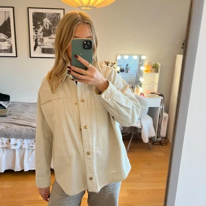 Beige jacka från Zara - Säljer en stilren beige jacka från Zara. Den har en avslappnad passform med knappar framtill och långa ärmar. Perfekt för lager-på-lager-stil och passar till många olika outfits.