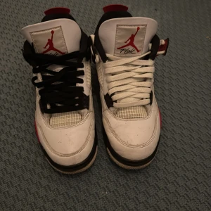 Jordan 4 red cement  - Snygga Nike Air Jordans med en klassisk design i vitt, rött och svart. Skorna har snörning och den ikoniska Jumpman-loggan på tungan och hälen. Perfekta för sneakerheads som älskar en tidlös stil. Skorna är helt äkta kan mötas upp och kollas upp. Kommer med box samt tvättar jag dem innan köp. Dem är köpta från foot Locker.