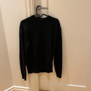 Svart stickad merinoull tröja  - Säljer en stilren svart stickad tröja av merinoull. Tröjan är bra kvalitet där den passar mig bra och jag är 180cm. Hör av dig vid frågor eller funderingar.