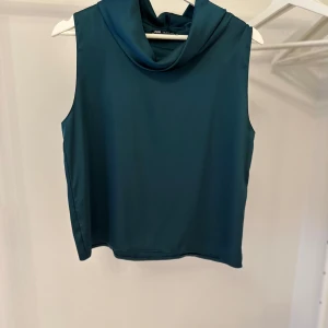 Mörkgrön ärmlös topp från Zara - Snygg mörkgrön ärmlös polotopp från Zara. Mjukt och bekvämt material med en stilren design, oanvänd.