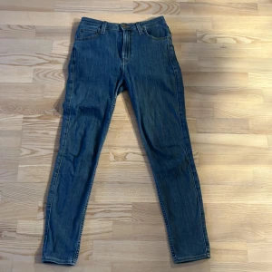 Blå jeans från Lee - Klassiska blå jeans från Lee. Tapered passform som sitter bra även på mindre storlekar. Sparsamt använda och slitstarka. Storlek 29/31 så passar även de som är lite kortare