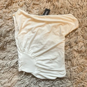 Vit offshoulder topp från Boohoo - Säljer en snygg vit offshoulder topp från Bohoo, har prislappen kvar då jag aldrig använt den. Storlek S