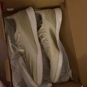 Beige sneakers från Adidas - Säljer ett par snygga beige sneakers från Adidas i storlek 38,5, inomhus skor som har används till fotboll, Skorna är i mycket bra skick och kommer i originalkartong.