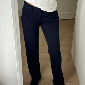 Kostymbyxor från InWear - Mörkblåa kostymbyxor från InWear i storlek 36. Byxorna är medelhöga i midjan och har en stilren design med diskreta fickor. Använda fåtal gånger och har inga tecken på användning!