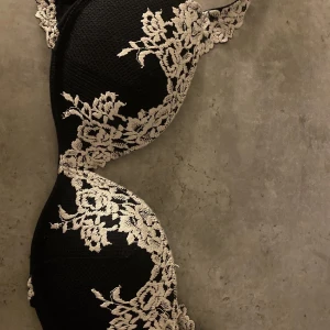Intimissimi bh - Säljer en elegant svart bh med vacker vit spetsdetaljering. Perfekt för att känna sig extra fin under kläderna. Den har en klassisk design med justerbara axelband för bästa passform. Passar både till vardags och speciella tillfällen.