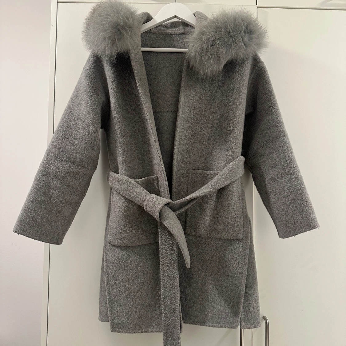 Grå kappa med pälsdetaljer
