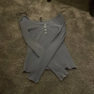 Grå ribbad topp från Pieces - Snygg grå ribbad topp från Pieces med långa ärmar och knappar framtill. Perfekt för en stilren look.