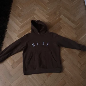 Brun hoodie från Nike - Säljer en brun hoodie från Nike med klassisk logga på bröstet. Perfekt för en avslappnad stil med sin bekväma passform och huva. Ett måste för garderoben!!!!!!