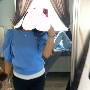 Blå tröja med puffärmar - Säljer en snygg blå tröja med puffärmar och rund halsringning.  Perfekt för en stilren look!