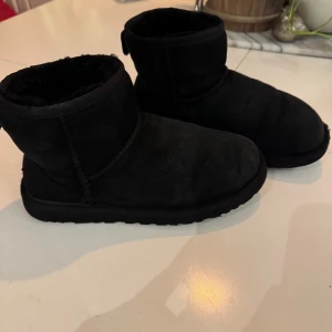 Svarta boots från UGG Australia - Säljer ett par svarta boots från UGG Australia. De är tillverkade i mocka och har en mjuk insida som håller fötterna varma. Perfekta för kyligare dagar. Bästa skorna på vintern! 