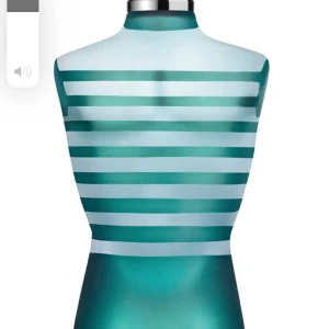 JPG Le Male - Snygg parfymflaska med ett coolt randigt mönster i olika nyanser av blått och grönt. Flaskan har en unik form som påminner om en manlig torso och en stilren metallkork. Perfekt för den som vill ha en stilfull och modern doft på hyllan.