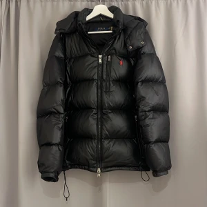 Svart dunjacka från Polo Ralph Lauren - Säljer en snygg svart dunjacka från Polo Ralph Lauren i storlek M! Sitter bra på mig som ät 182,5 men passar båda större och mindre! Vid fler frågor osv skriv gärna! Har en liten lagning 