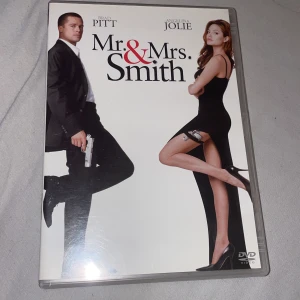 Mr. & Mrs. Smith DVD - Säljer en DVD av filmen 'Mr. & Mrs. Smith' med Brad Pitt och Angelina Jolie. Filmen handlar om ett gift par som upptäcker att de båda är hemliga agenter för konkurrerande organisationer. DVD:n innehåller extramaterial som biotrailer, kommentatorspår, borttagna scener och skapandet av en scen. Perfekt för actionälskare!