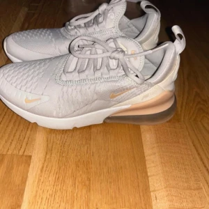 Nike sneakers i ljusgrått - Säljer ett par snygga Nike Air 270 i ljus färg. Skorna är endast använda 2-3 gånger och är i nyskick, ingen slitage eller skada! Säljes då de inte passade efter graviditet.