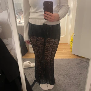 Svarta spetsbyxor - Snygga svarta byxor i spetsmaterial med ett genomskinligt mönster. De har en loose passform och är perfekta för en trendig look. Byxorna är lågmidjade. Har sytt precis mellan benenndå det blev ett litet hål!