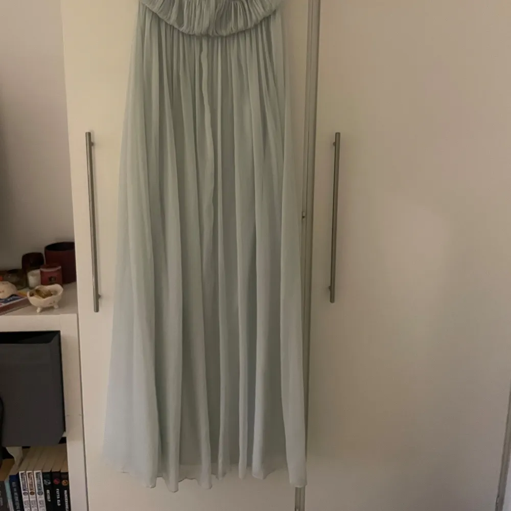 Elegant ljusgrön axelbandslös långklänning med draperad överdel och knytning framtill. Perfekt för en somrig fest eller bal. Köpt på Vinted, har själv aldrig anvönt klänningen men förra ägare använde den en gång . Mekot.