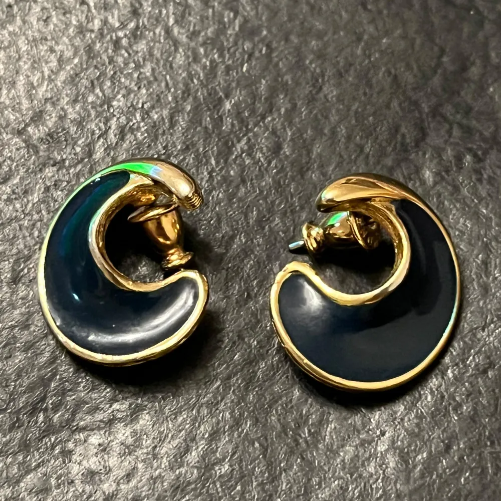 Vintage Snygga örhängen i en unik, böjd design från Monet. De har en elegant kombination av guld och svart, vilket ger en stilren look. Perfekta för att lyfta vilken outfit som helst.. Asusteet.