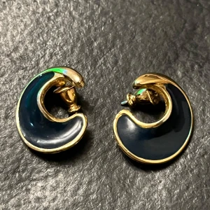 Vintage Guldplaterad örhängen från Monet - Vintage Snygga örhängen i en unik, böjd design från Monet. De har en elegant kombination av guld och svart, vilket ger en stilren look. Perfekta för att lyfta vilken outfit som helst.