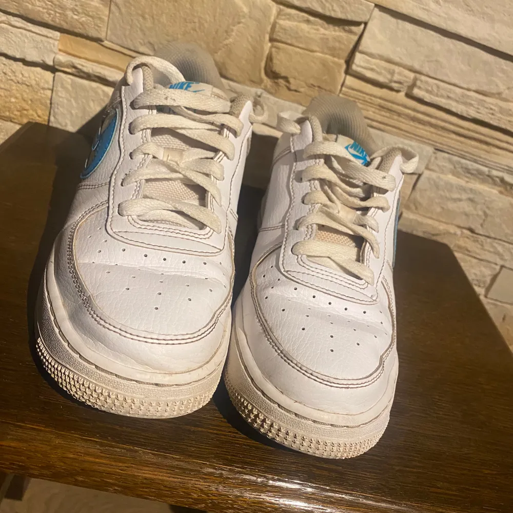   Nike Air Force 1 Low GS White Aqua – Storlek 38,5 EU  Säljes ett par Nike Air Force 1 Low GS i färgen White Aqua. Skorna har en stilren vit överdel i läder med den ikoniska Swoosh-loggan i blått (Aqua). 	•	Storlek: 38,5 EU 	•	Modell: Nike Air Force 1 Low GS White Aqua 	•	Skick: Skorna har tecken på användning, men är fortfarande i bra skick för att användas. De kan behöva en lätt rengöring för att återfå sin fulla potential.  Perfekta för dig som letar efter et. Kengät.