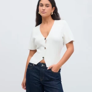 Vit kofta från Gina Tricot - Säljer en stilren vit kofta från Gina Tricot i storlek S. Koftan har korta ärmar och knappar framtill, perfekt för en elegant look. Den är tillverkad i ett mjukt material som ger en bekväm passform. Aldrig använd och prislappen är kvar!💕