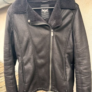 Rockig svart jacka från Black Premium by EMP! - Svart rockig jacka med mjukt foder och snygga detaljer i storlek XL (dam) M (herr) från Black Premium by EMP. Den är sparsamt använd och i nyskick. 