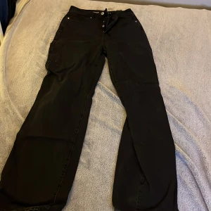 Svarta jeans med regular wide passform - Snygga svarta jeans med en regular wide passform. De har en midja på 28 och längd 32. Perfekta för en avslappnad stil med en klassisk look.