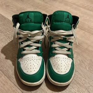 Gröna och vita Nike Air Jordans - Säljer ett par gröna och vita Nike Air Jordans med klassisk snörning och perforerad tå. Skorna har den ikoniska Air Jordan-loggan på sidan och är perfekta för sneaker-entusiaster. Priset kan diskuteras