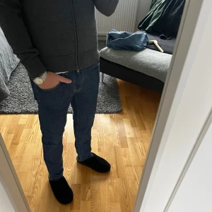 Blå jeansbyxor J Lindberg - Snygga blå jeansbyxor med en klassisk straight passform. De har en dragkedja och knappar framtill samt fem fickor. Perfekta för en avslappnad stil.