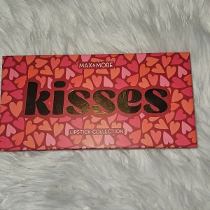 Kisses Lipstick Collection från Max & More - Upptäck Kisses Lipstick Collection från Max & More med sex olika nyanser: Velvet Lips, Tender Kiss, Rocking Red, Pleased, Sweet Crush och Cheeky Coral. Perfekt för att variera din look med dessa livfulla färger. Förpackningen är dekorerad med hjärtan i rosa och orange toner. Köpt för ungefär 200kr i Tyskland. Aldrig använt. 6 stycken läppstift.
