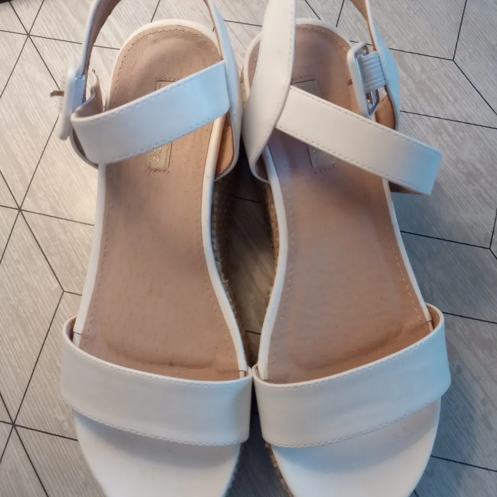 Snygga vita sandaler från Primadonna med breda remmar och justerbart spänne. Sandalerna har en hög sula som ger en trendig look. Perfekta för sommarens alla tillfällen.. Kengät.