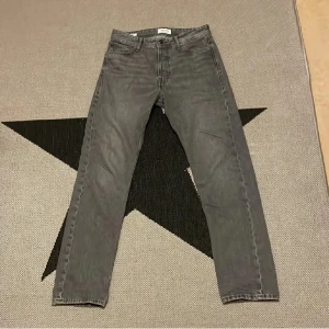 Grå jeansbyxor - Snygga grå jeansbyxor med klassisk femficksdesign och dragkedja. Perfekta för en avslappnad stil.