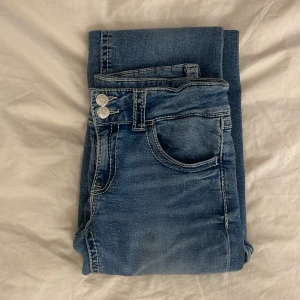Blå jeansbyxor - Snygga blå jeansbyxor med klassisk femficksdesign och knappgylf. Perfekta för en avslappnad stil.❤️ Köpta i somras från Gina tricot i storlek 164 för 300 kr❤️Har en liten defekt som man ser på bild 2 men inget som märks❤️hör av dig vid frågor❤️