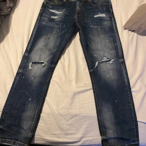 Blå jeans från Supply & Demand - Säljer ett par blå jeans från Supply & Demand alldrig använda, med slitna detaljer och en cool, avslappnad look. De har en klassisk femficksdesign och är perfekta för en casual stil. Märket är baserat i New York City. Priset är ej skrivet i sten, Skriv ett PM för frågor,bilder etc 