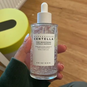 Centella Tone Brightening Capsule Ampoule - Centella Tone Brightening Capsule Ampoule från SKIN1004 innehåller ren centella från Madagaskar. Flaskan rymmer 100 ml och är designad med en praktisk pipett för enkel applicering. Perfekt för att ge huden en ljusare ton och extra lyster.