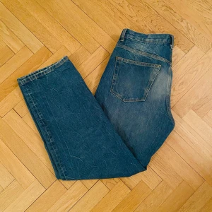 Weekday Galaxy Loose Straight Jeans - Säljer ett par blå Weekday Galaxy Loose Straight Jeans till ett dunder pris. Köpte de på rea för att ha på en fest med tema, i princip oanvända. De har en avslappnad passform med raka ben och klassisk femficksdesign. Perfekta för en casual look. W30 L32. Meddela om du har frågor.
