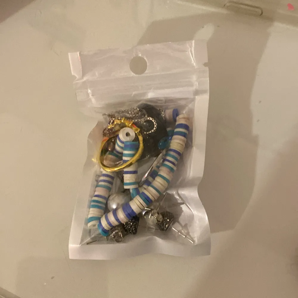 En ”mystery bag” som innehåller ringar, halsband, örhängen, armband och berlonger. Allt är i användt/nytt skick. Sammanlagt 10 accessoarer😊. Asusteet.