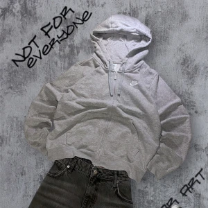 Grå hoodie från Nike - Säljer en klassisk grå hoodie från Nike med dragkedja och huva. Tröjan har en broderad Nike-logga på bröstet. Perfekt för en avslappnad stil.